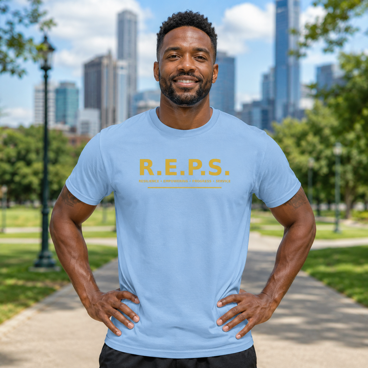 Man wearing the light blue R.E.P.S. Gold Standard Tee in a city park